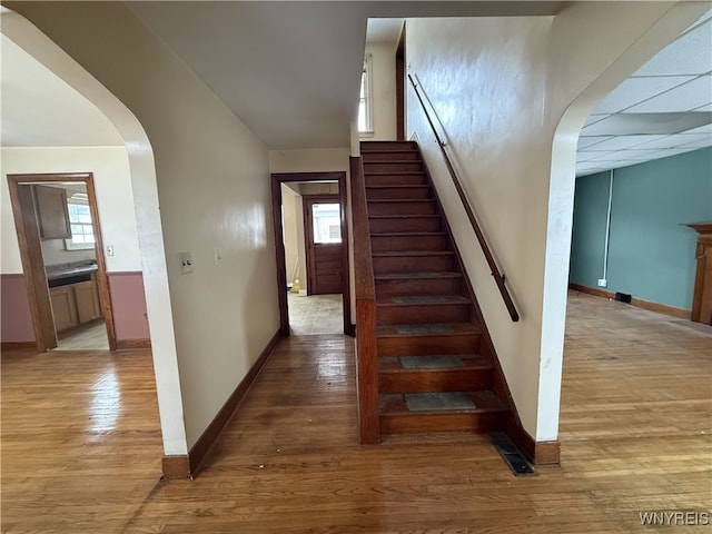 1475 Orchard Park Rd, West Seneca, NY 14224 - staircase featuring arched walkways, baseboards, and wood finished floors