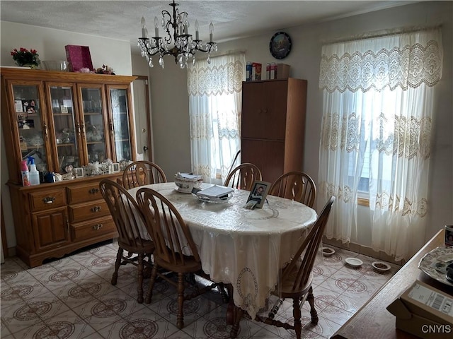 dining room featuring light tile patterned flooring and a notable chandelier