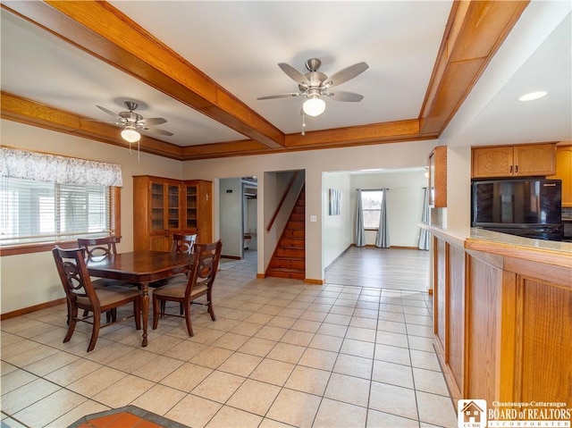 dining room featuring light tile patterned floors, baseboards, ceiling fan, stairway, and beamed ceiling