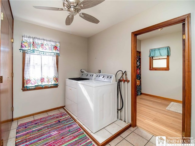 clothes washing area featuring light tile patterned floors, ceiling fan, washer and dryer, laundry area, and baseboards