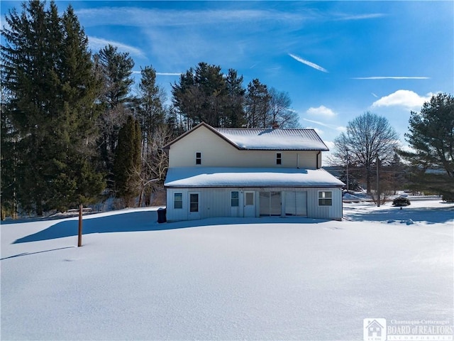 view of snow covered back of property