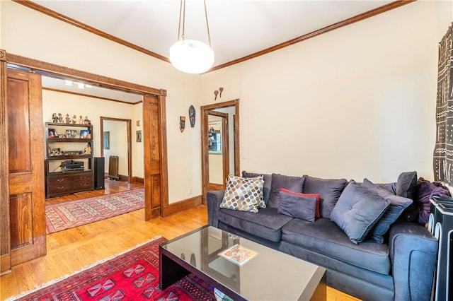 living room featuring light wood-style flooring, baseboards, and ornamental molding