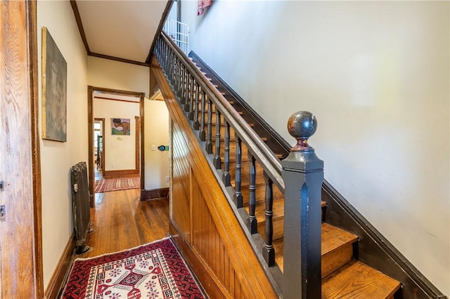 staircase with baseboards, wood finished floors, and crown molding