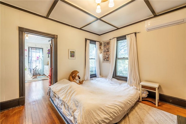 bedroom with access to outside, coffered ceiling, a wall mounted AC, and wood-type flooring