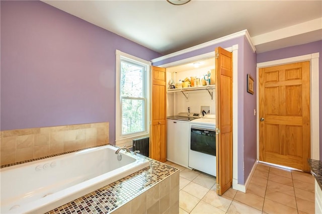 laundry room featuring radiator heating unit, light tile patterned floors, baseboards, laundry area, and washing machine and clothes dryer