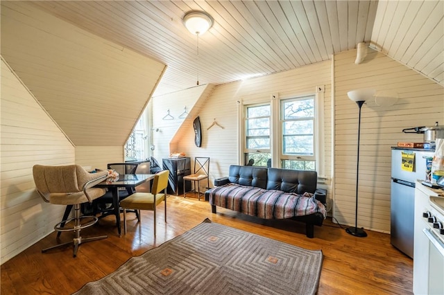 interior space with wood walls, wooden ceiling, lofted ceiling, and wood finished floors