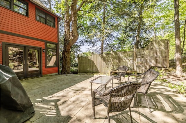 view of patio with french doors and fence