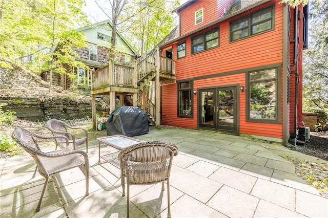 view of patio featuring area for grilling, french doors, and stairs