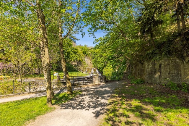 view of property's community featuring a gate, fence, and a wooded view