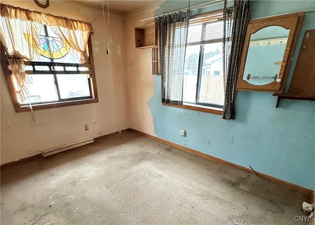 empty room featuring a baseboard radiator and baseboards