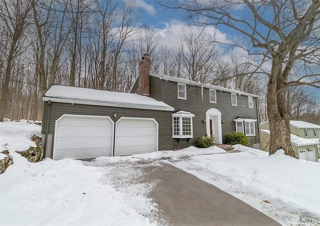 colonial home with a garage and a chimney