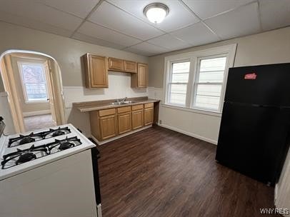 kitchen featuring light countertops, a wealth of natural light, freestanding refrigerator, and white range with gas stovetop