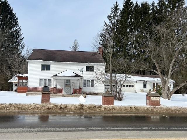 view of front of property with a garage, a chimney, and a water view