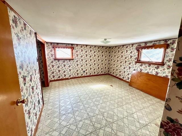 unfurnished room featuring wallpapered walls, baseboards, and tile patterned floors