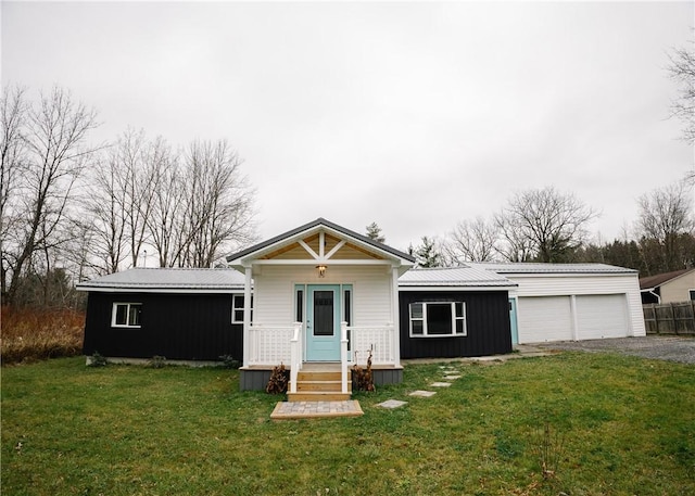 view of front of property featuring a garage, metal roof, and a front lawn