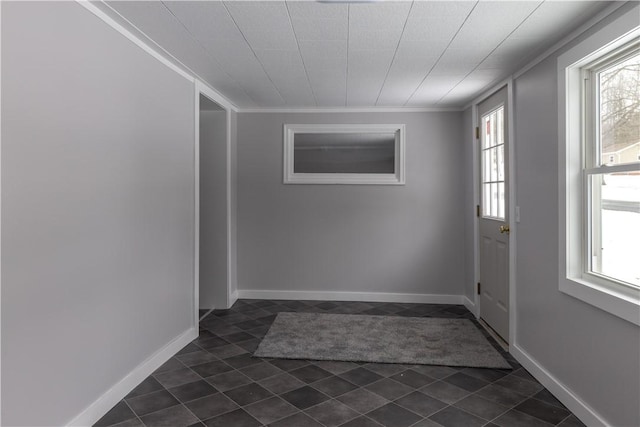 entryway with baseboards and crown molding