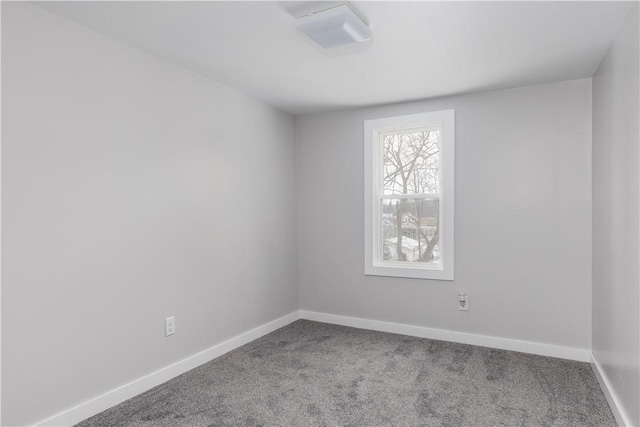 carpeted empty room featuring baseboards