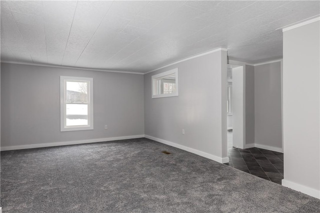 unfurnished room featuring ornamental molding, dark carpet, and baseboards