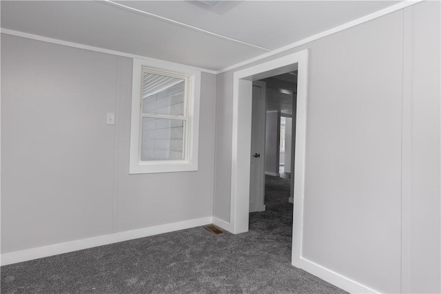 unfurnished room featuring visible vents, baseboards, and dark colored carpet