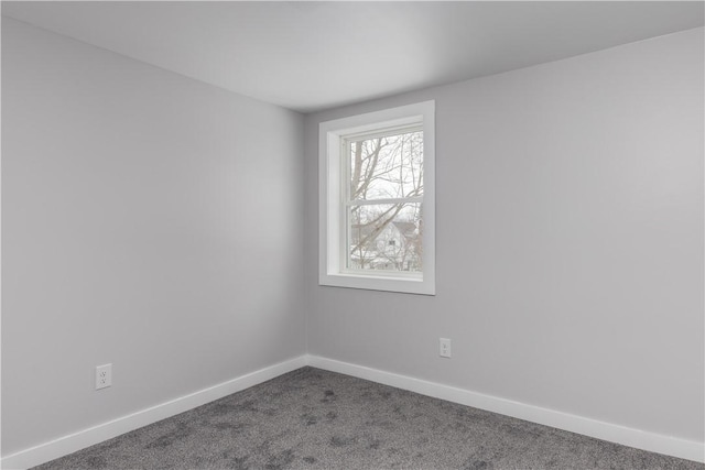 spare room featuring carpet and baseboards