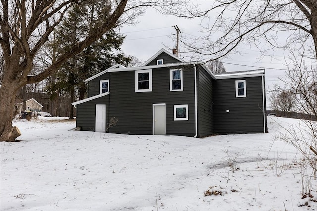 view of snow covered rear of property