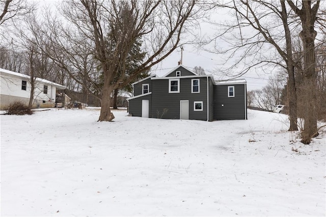 snow covered house featuring a garage