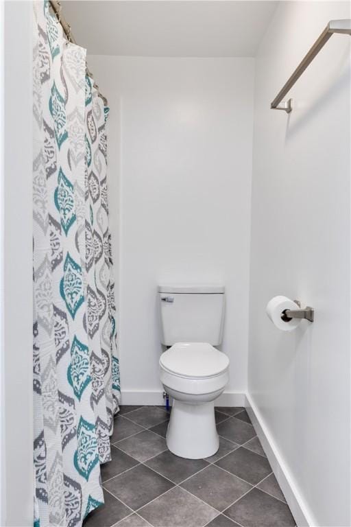 full bathroom with tile patterned flooring, toilet, and baseboards