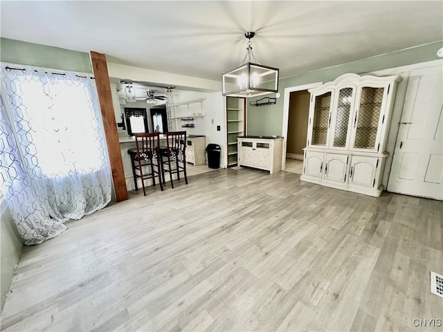 interior space with light wood-type flooring, visible vents, and a ceiling fan