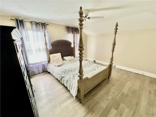 bedroom featuring light wood-type flooring, baseboards, and a ceiling fan