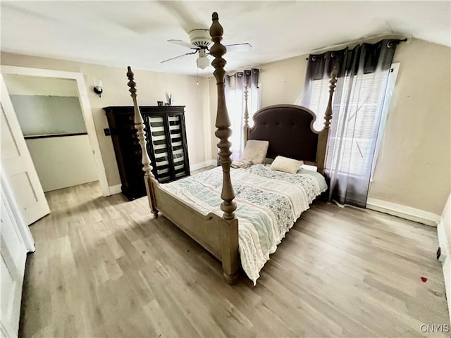 bedroom with ceiling fan, baseboards, and light wood-style floors