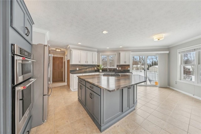 kitchen with gray cabinetry, dark countertops, backsplash, and white cabinets