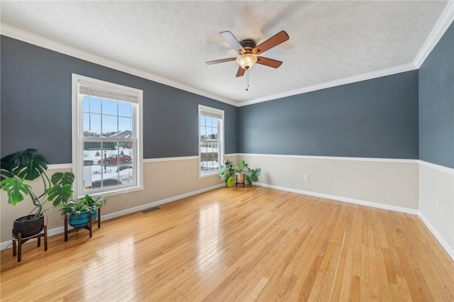 interior space featuring crown molding, visible vents, a ceiling fan, a textured ceiling, and light wood-type flooring