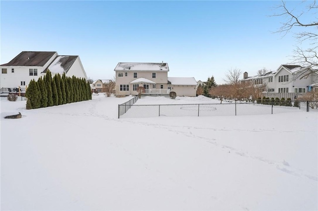 yard layered in snow featuring a residential view and fence