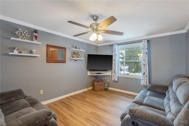 living room with ceiling fan, crown molding, baseboards, and wood finished floors