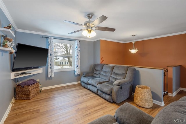 living area with baseboards, wood finished floors, and crown molding