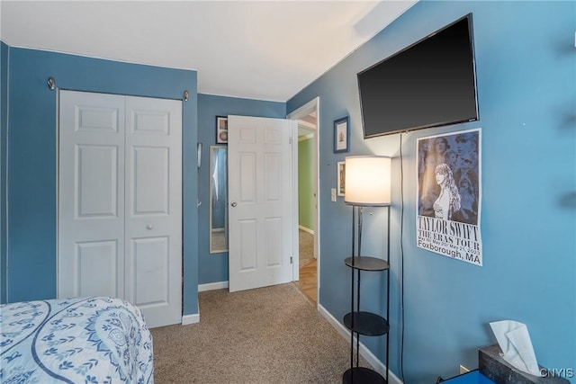 bedroom with light carpet, baseboards, and a closet