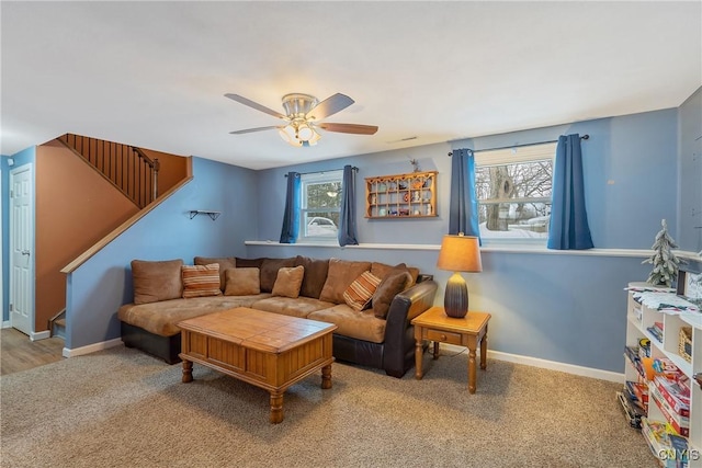 living room featuring carpet floors, baseboards, stairway, and a wealth of natural light