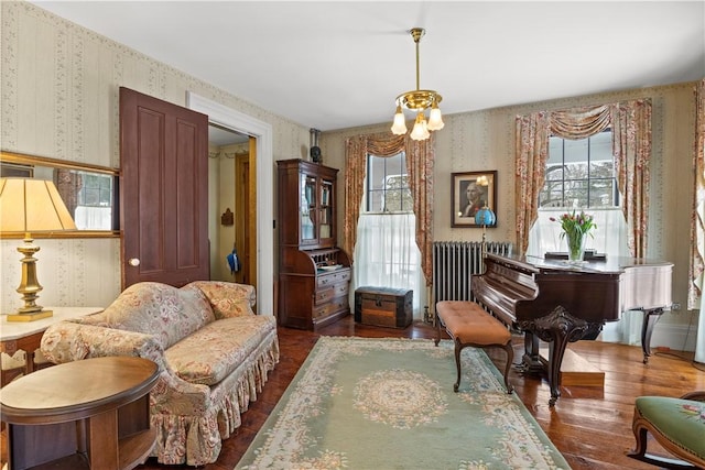 sitting room featuring a wealth of natural light, dark wood finished floors, radiator heating unit, and wallpapered walls