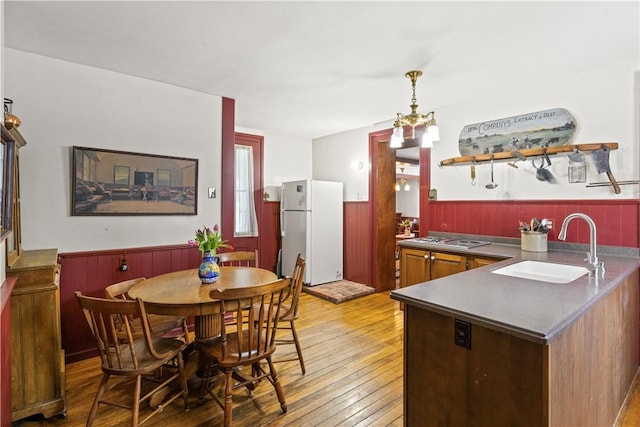 dining area with a wainscoted wall and light wood finished floors