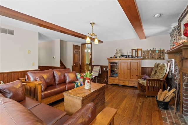 living area with visible vents, wainscoting, stairway, wood finished floors, and beam ceiling