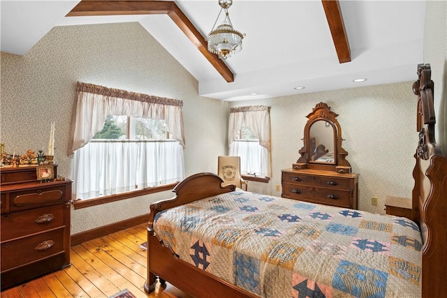 bedroom with wallpapered walls, baseboards, hardwood / wood-style floors, vaulted ceiling with beams, and an inviting chandelier