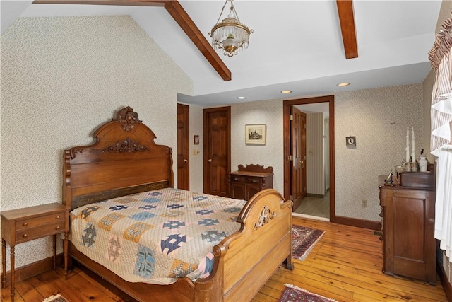 bedroom with light wood-style flooring, lofted ceiling with beams, baseboards, and wallpapered walls