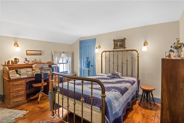 bedroom with vaulted ceiling and hardwood / wood-style floors