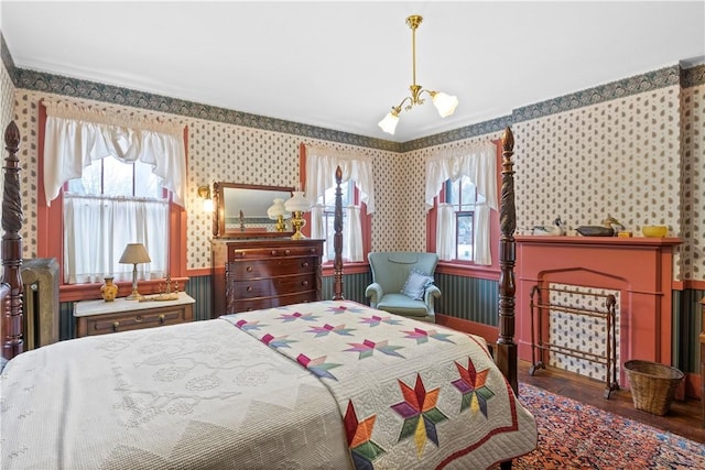 bedroom featuring wallpapered walls, multiple windows, a notable chandelier, and wood finished floors