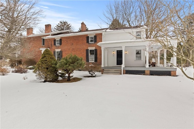 view of front of house with brick siding and a chimney