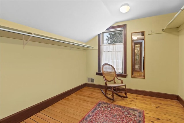 spacious closet featuring lofted ceiling, light wood finished floors, and visible vents