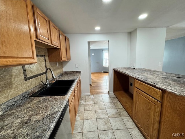 kitchen featuring light tile patterned floors, a sink, decorative backsplash, dishwasher, and brown cabinetry