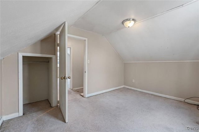 bonus room featuring lofted ceiling, light colored carpet, and baseboards