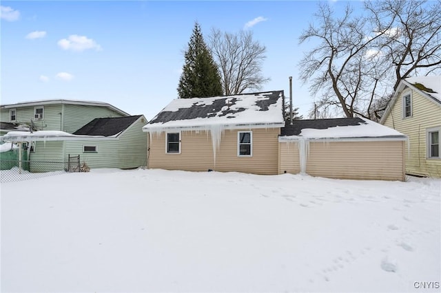 snow covered back of property with fence