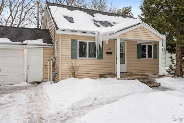 view of front of property featuring a garage and a shingled roof